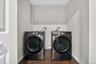 State of the art washer and dryer. Dedicated laundry area with a dark wood-finish floor