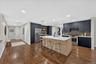 Kitchen featuring a center island with countertop seating, dark blue cabinetry, wood-finish flooring, recessed lighting, and stainless steel appliance
