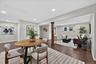 Recessed lighting, wood-finish flooring, light grey wall paint, white trim, and a wood-wrapped column