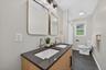 Dual vanity with integrated sinks, brushed nickel fixtures, two framed mirrors, and a dark stone countertop