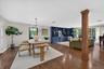 Loft-like, Open Floor plan--Hardwood flooring throughout, built-in shelving, large windows with exterior foliage, and a rectangular chandelier