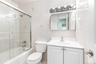 Bathroom featuring a white vanity with integrated sink, chrome faucet, and a medicine cabinet with a vanity light fixture