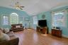 Oversized family room with vaulted ceiling, tons of light and sliding doors to level yard
