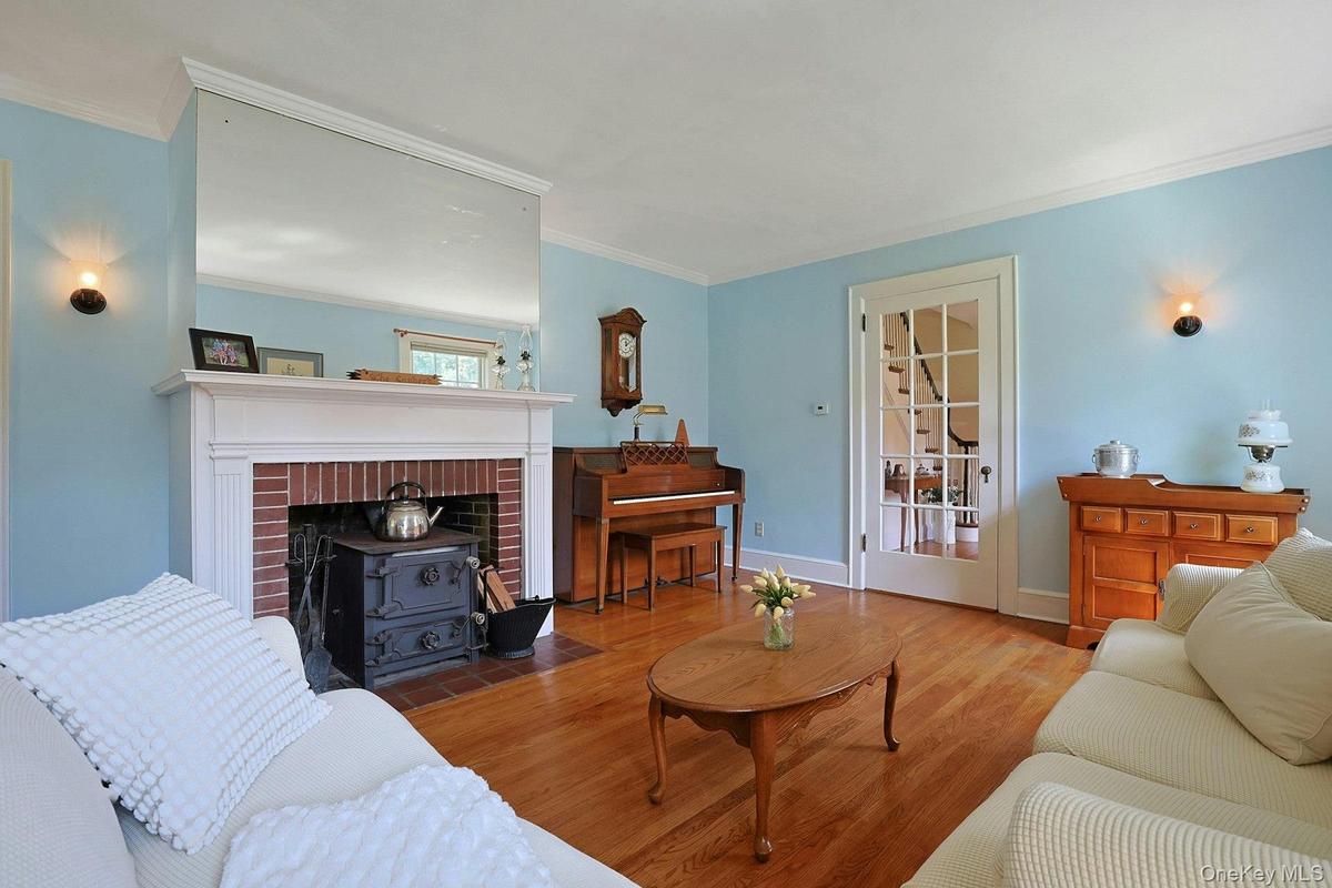 Formal living room with French door and fireplace with wood burning stove insert,