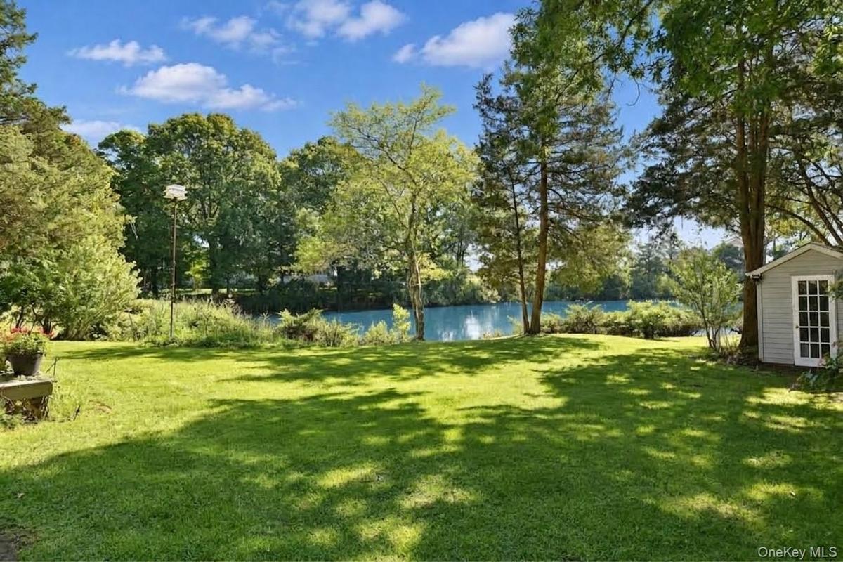 Large yard with gardens and a shed