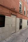 Brick exterior with a paneled door leading to basement