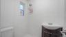 Bathroom featuring vanity, tiled shower, and toilet