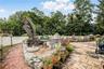 Expansive patio featuring flagstone paving, a stone-faced retaining wall, and a brick pathway
