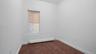 Spare room featuring a baseboard heating unit and dark hardwood / wood-style flooring