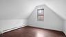 Additional living space with dark hardwood / wood-style flooring, a baseboard heating unit, and vaulted ceiling