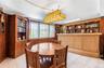Wood-paneled room featuring extensive built-in shelving, a patterned bar with a built-in display, and tiled flooring