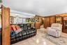 Tiled flooring, wood paneling, built-in media cabinetry, and a pass-through opening