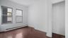 Empty room featuring baseboard heating and dark wood-type flooring