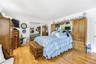 Hardwood flooring, built-in mirrored cabinetry, sliding mirrored closet doors, recessed lighting, and a white paneled door