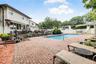 Swimming pool with a water slide, surrounded by a brick paver patio and privacy fencing