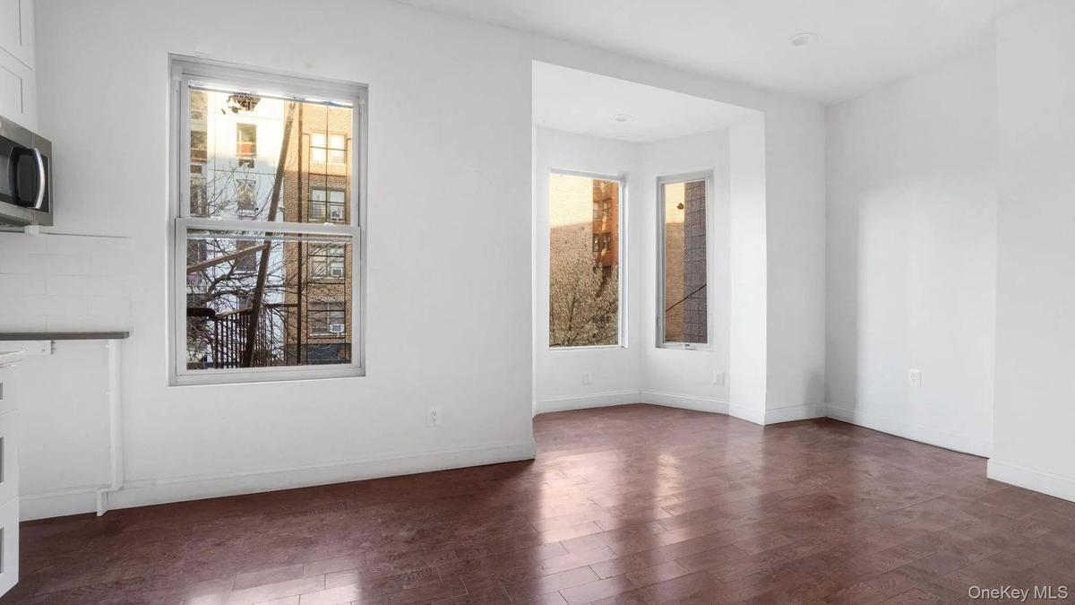 Empty room featuring dark hardwood / wood-style floors and a wealth of natural light