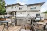 Expansive stone patio featuring a stone-faced raised planter and white privacy fencing