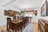 Hardwood flooring, chandelier lighting, white walls, and a built-in display cabinet