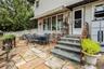 Expansive stone patio with natural stone steps and wrought iron railings