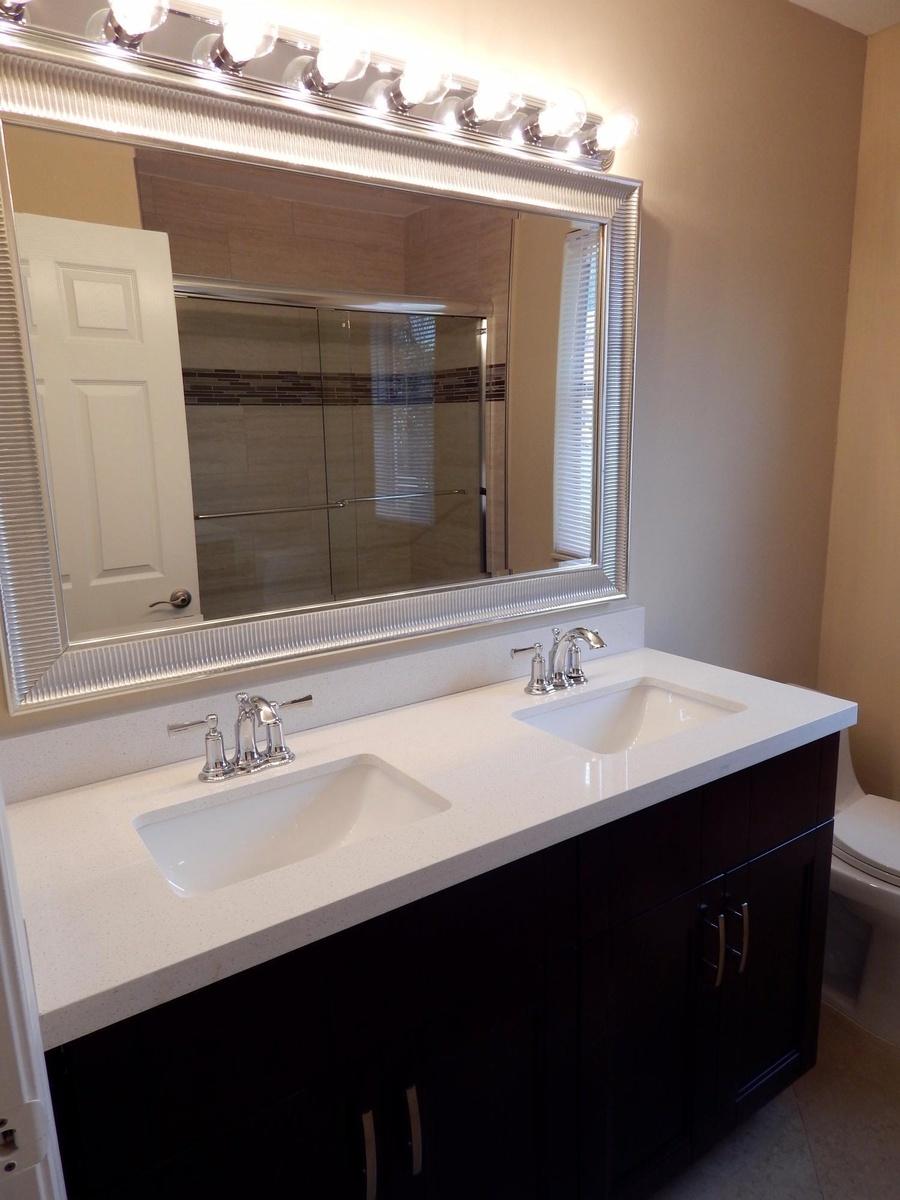Dual vanity featuring white countertops, undermount sinks, and chrome faucets