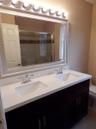 Dual vanity featuring white countertops, undermount sinks, and chrome faucets