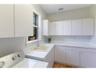 The spacious laundry room offers ample cabinetry and a utility sink for ease of living