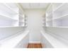 This large pantry is just off the kitchen and features custom built in shelving