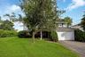 WELCOME HOME to 29 Randy Lane! Three-story residence featuring a front lawn, mature tree, attached two-car garage, and a covered entry. Grass enhanced