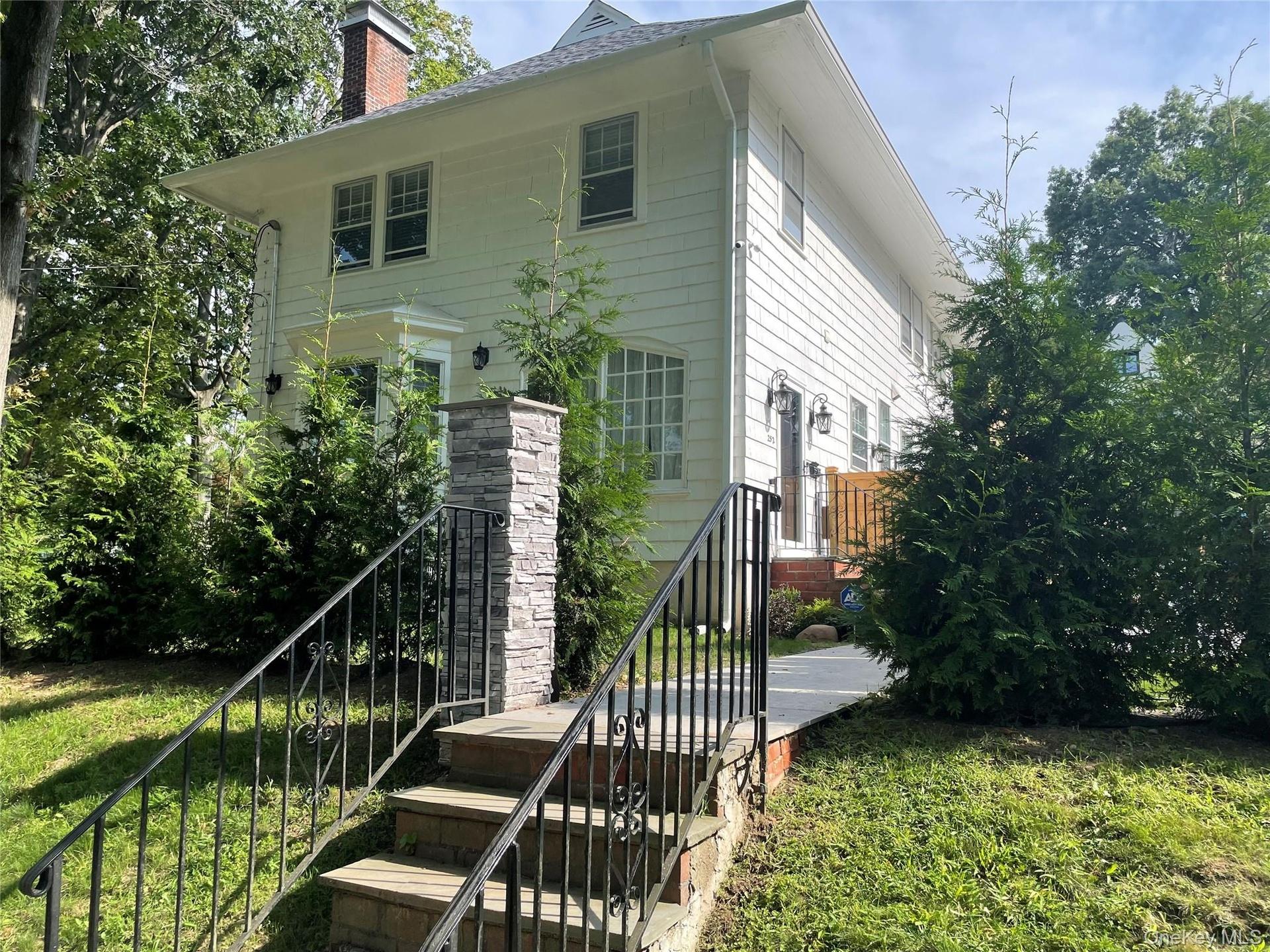White siding exterior with a brick chimney