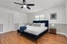 Bright bedroom featuring wood flooring and ceiling fan