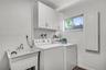 Well-equipped laundry room with built-in cabinetry for extra storage
