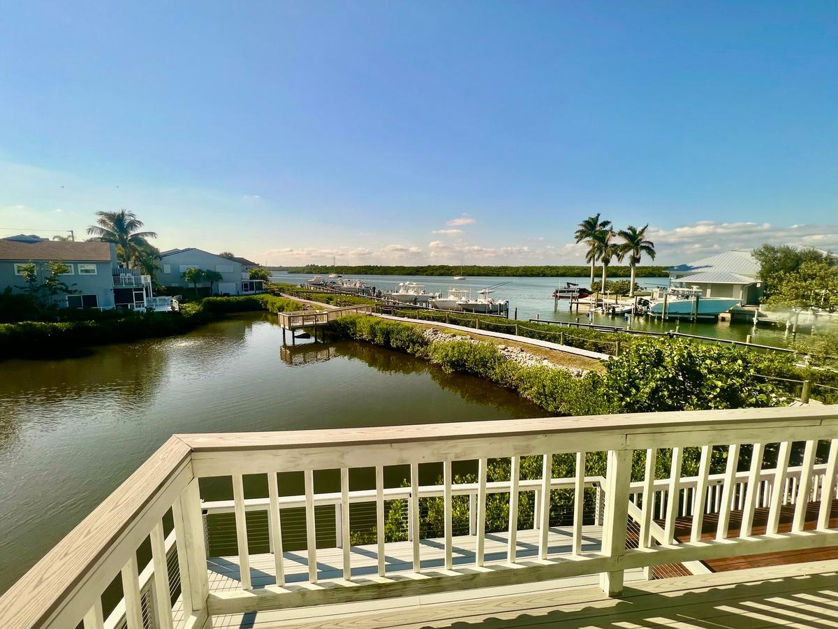 Waterfront setting with a private balcony, dock access, and mature palm trees