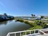 Waterfront property featuring a private boat dock, marina access, and tropical landscaping