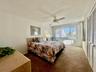 Ceiling fan, window with vertical blinds, and louvered bifold closet doors