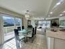 White tile flooring, sliding glass doors, a decorative chandelier, recessed lighting, and a granite countertop