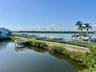 Waterfront setting featuring a wooden dock, boat slips, and lush green landscaping