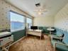 Textured wall covering with patterned accents, dual windows featuring horizontal blinds, ceiling fan with integrated lighting, and plush carpet floori