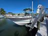Waterfront access featuring a white boat lift and a wood-plank dock