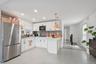 Beautifully updated kitchen featuring modern white cabinetry, stainless steel appliances, tile backsplash, recessed lighting, and a spacious open-conc