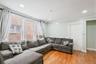 Bright and spacious living room featuring hardwood floors, recessed lighting, and abundant natural light from multiple windows. 1st Floor.