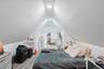 Upper-level bedroom featuring vaulted ceilings, recessed lighting, updated flooring, and a flexible layout with space for a work or study area. 2nd Fl