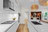Bright chef’s kitchen featuring built-in oven, sleek backsplash, and spacious island ideal for cooking and social gatherings.