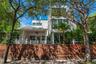 Contemporary façade surrounded by tropical landscaping — boutique Miami Beach townhouse near the ocean and parks.
