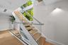 Sleek architectural staircase with modern railing — statement feature connecting both levels with open-air flow.
