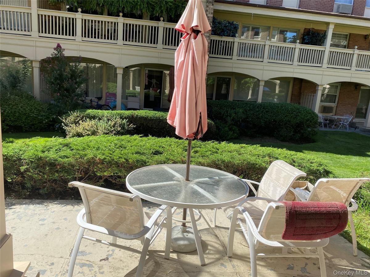 Paved patio area, manicured lawn, and established shrubbery