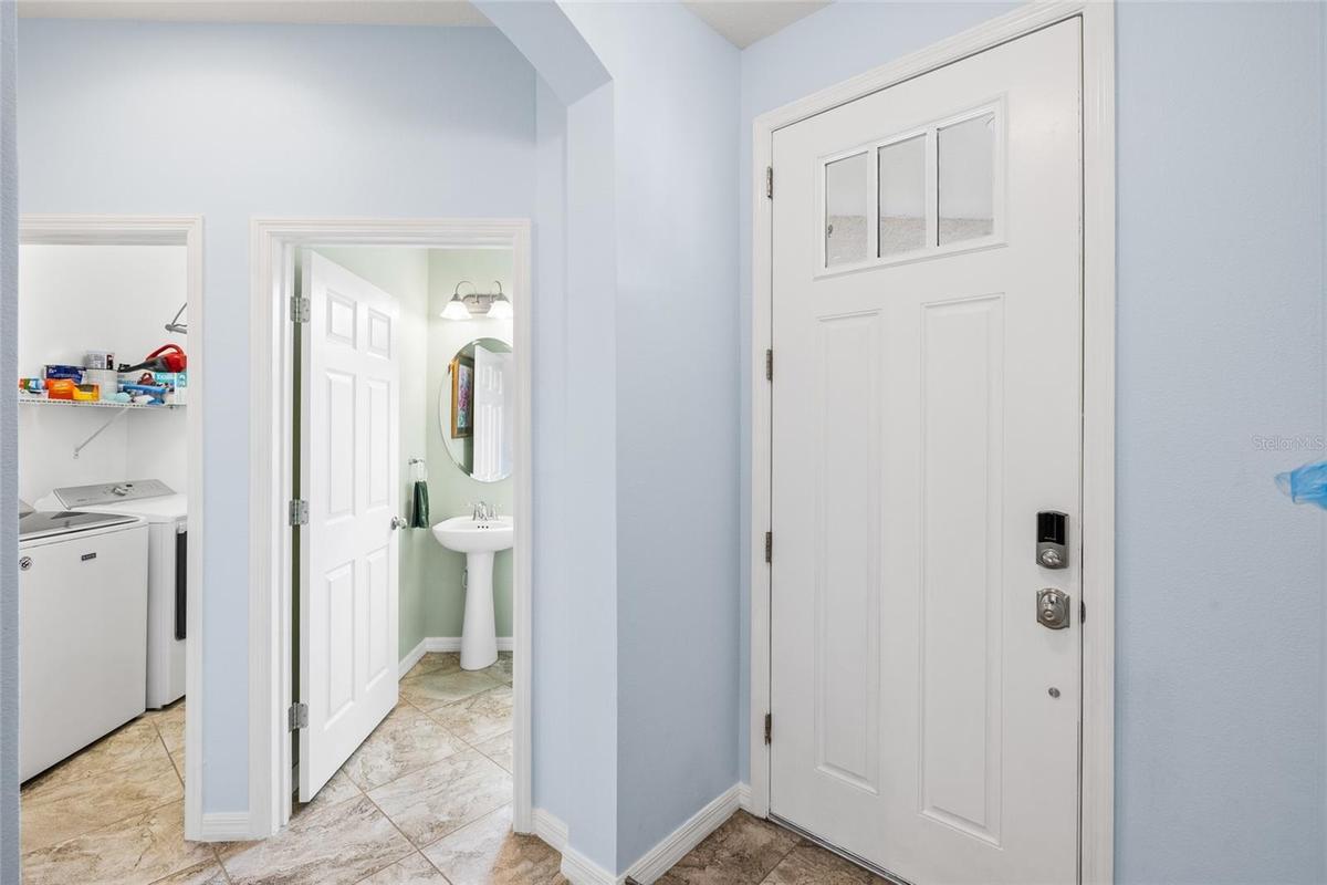 Foyer looking toward half bath and interior laundry room