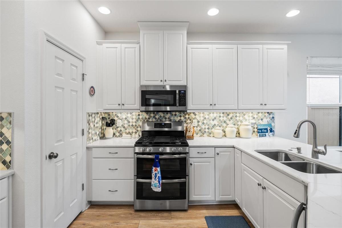 Kitchen with gas cooktop, spacious pantry.