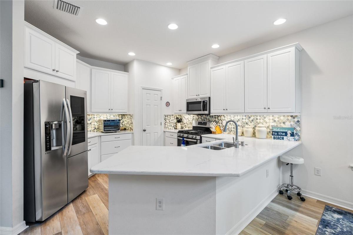 Beautiful chef's kitchen with quartz countetops, real wood cabinets and spacious pantry