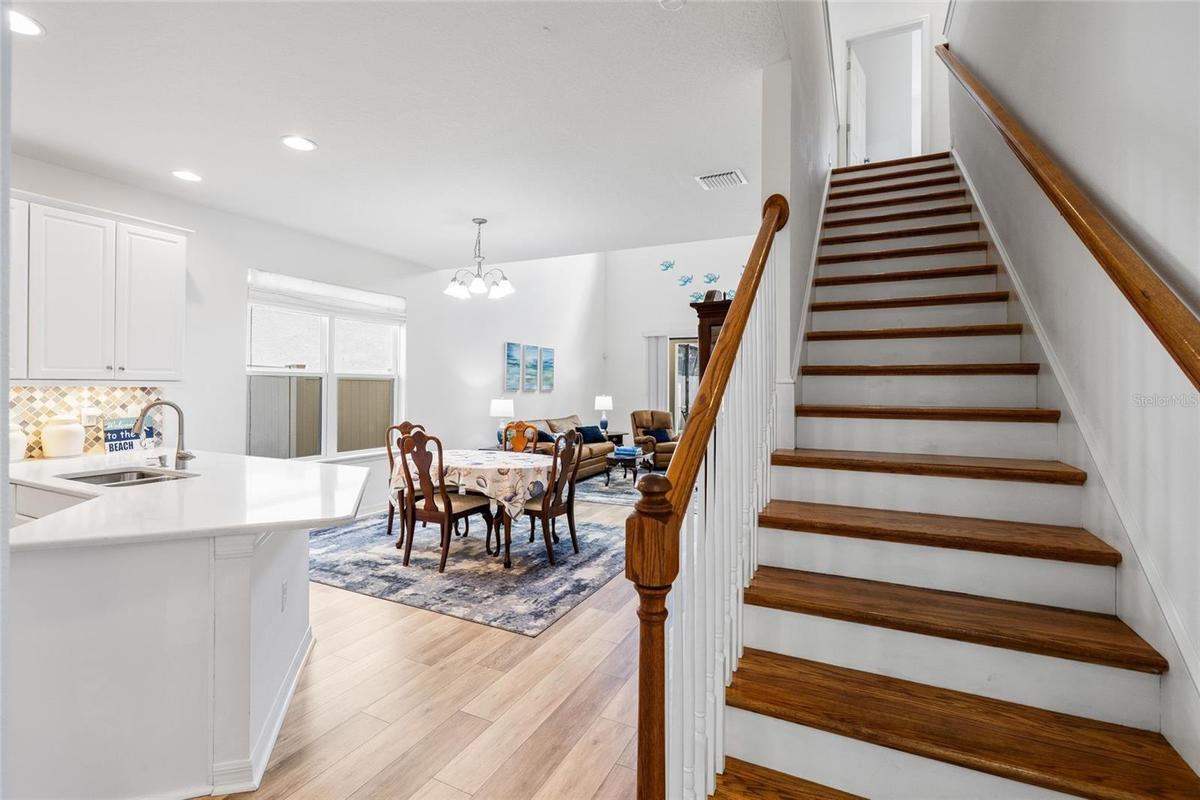 View of stairs, into kitchen, dining area and great room.