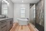 Renovated Primary Bath with Freestanding Tub and Accent Tile Wall